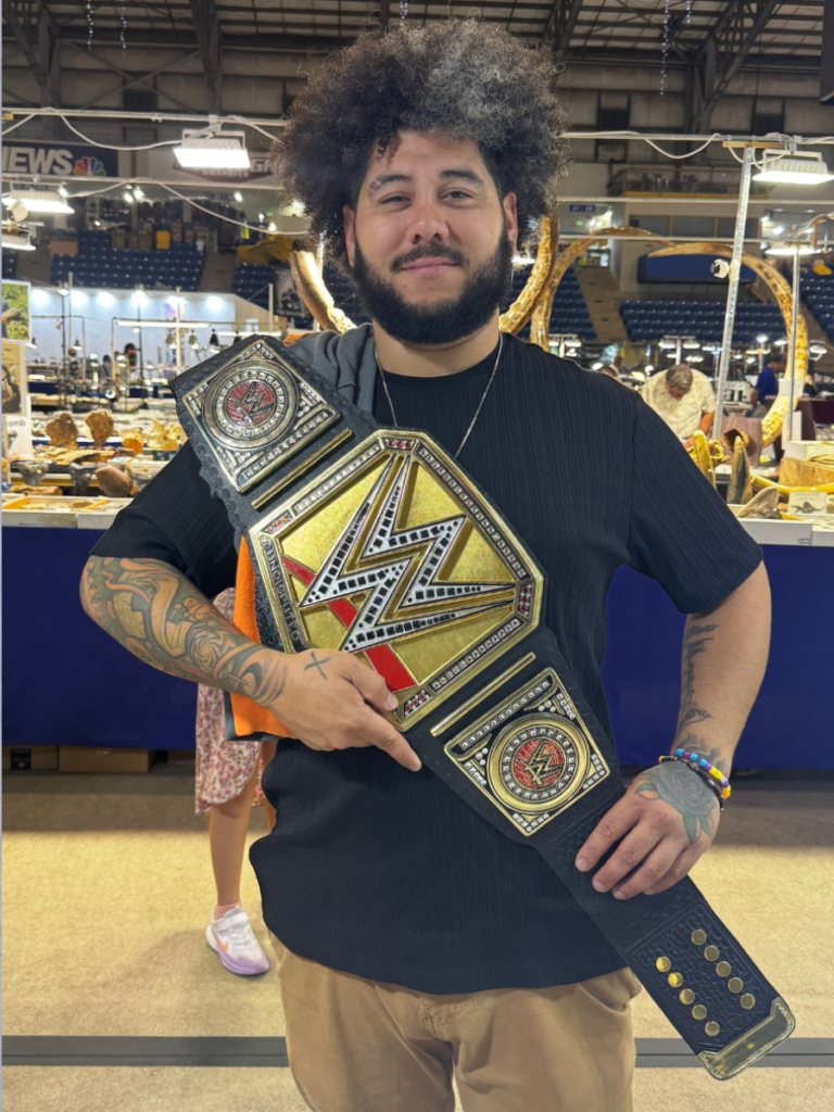 A buyer holding a K2 championship belt purchased at a US trade show